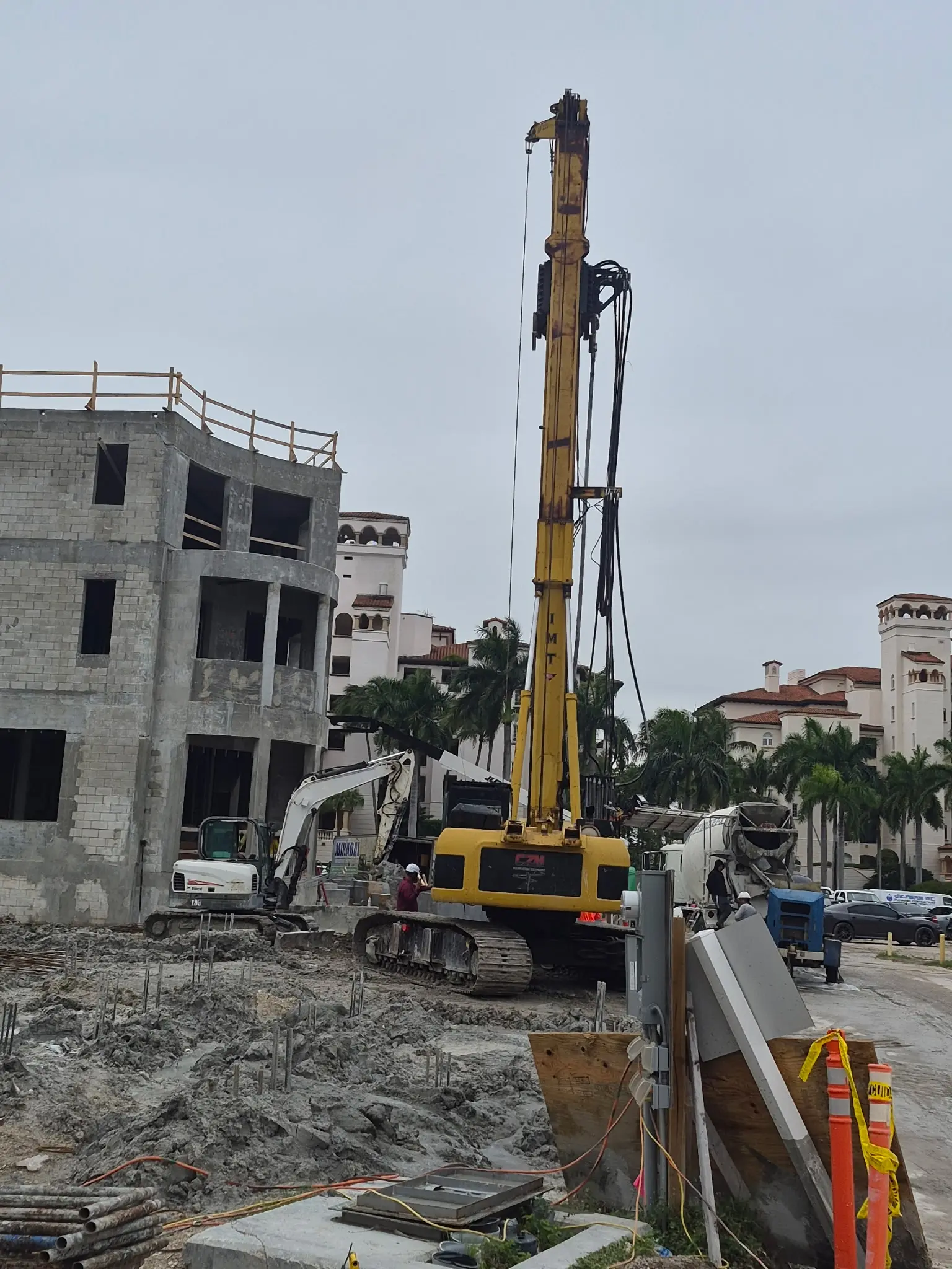 Drilling rig positioned next to a multi-story concrete structure