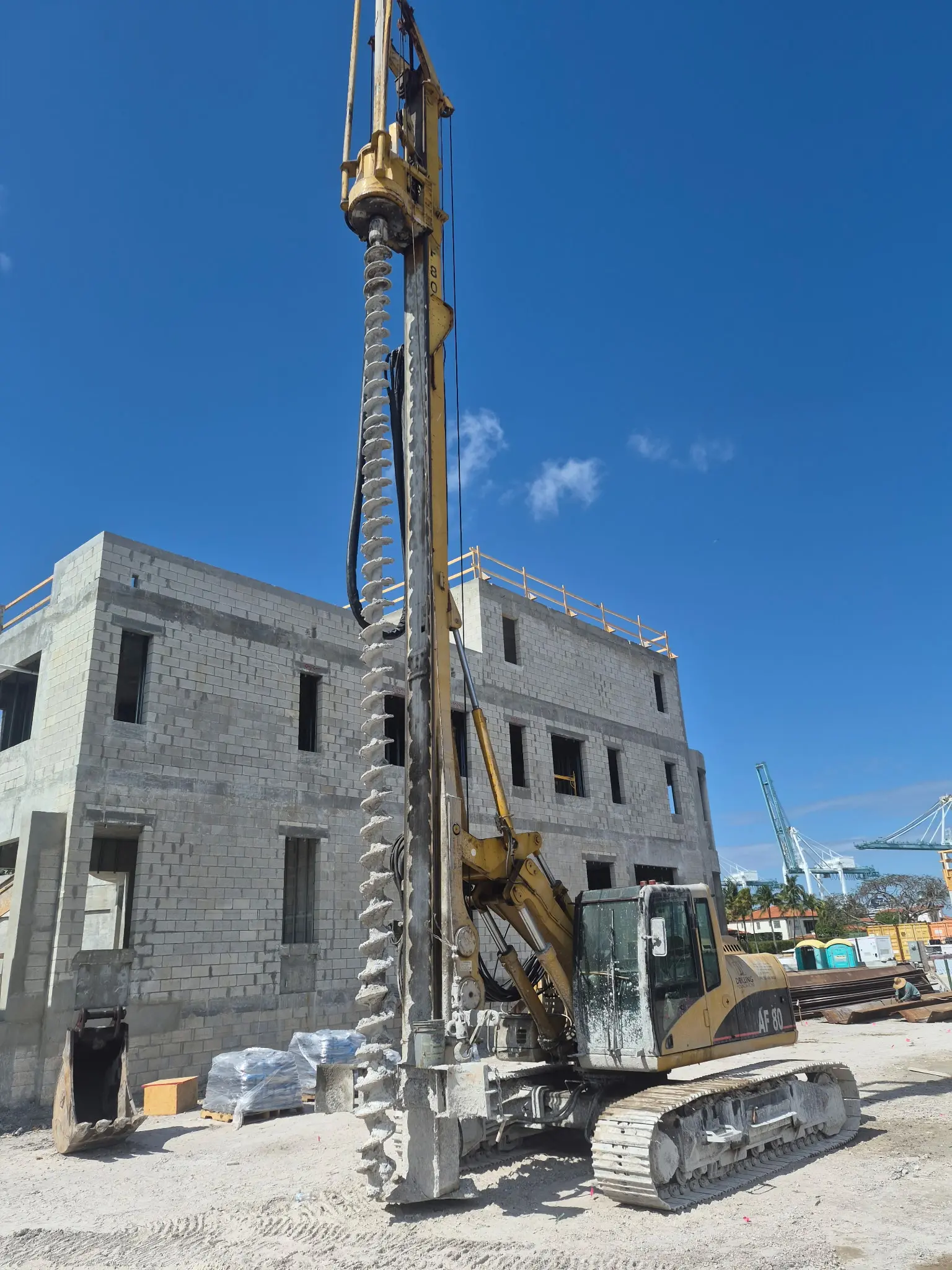 Drilling rig working next to a concrete building frame