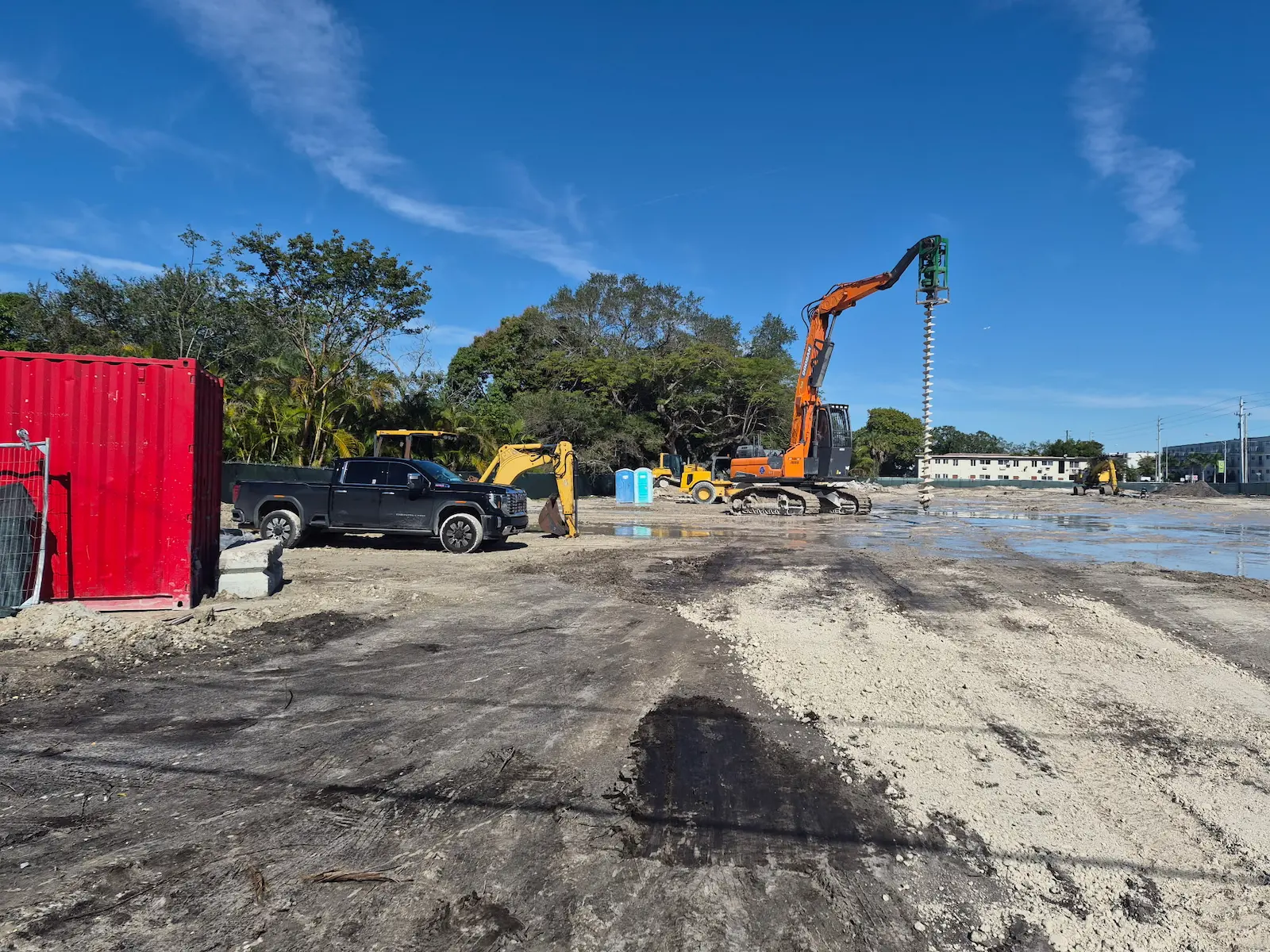 Excavator and rig grading a commercial site