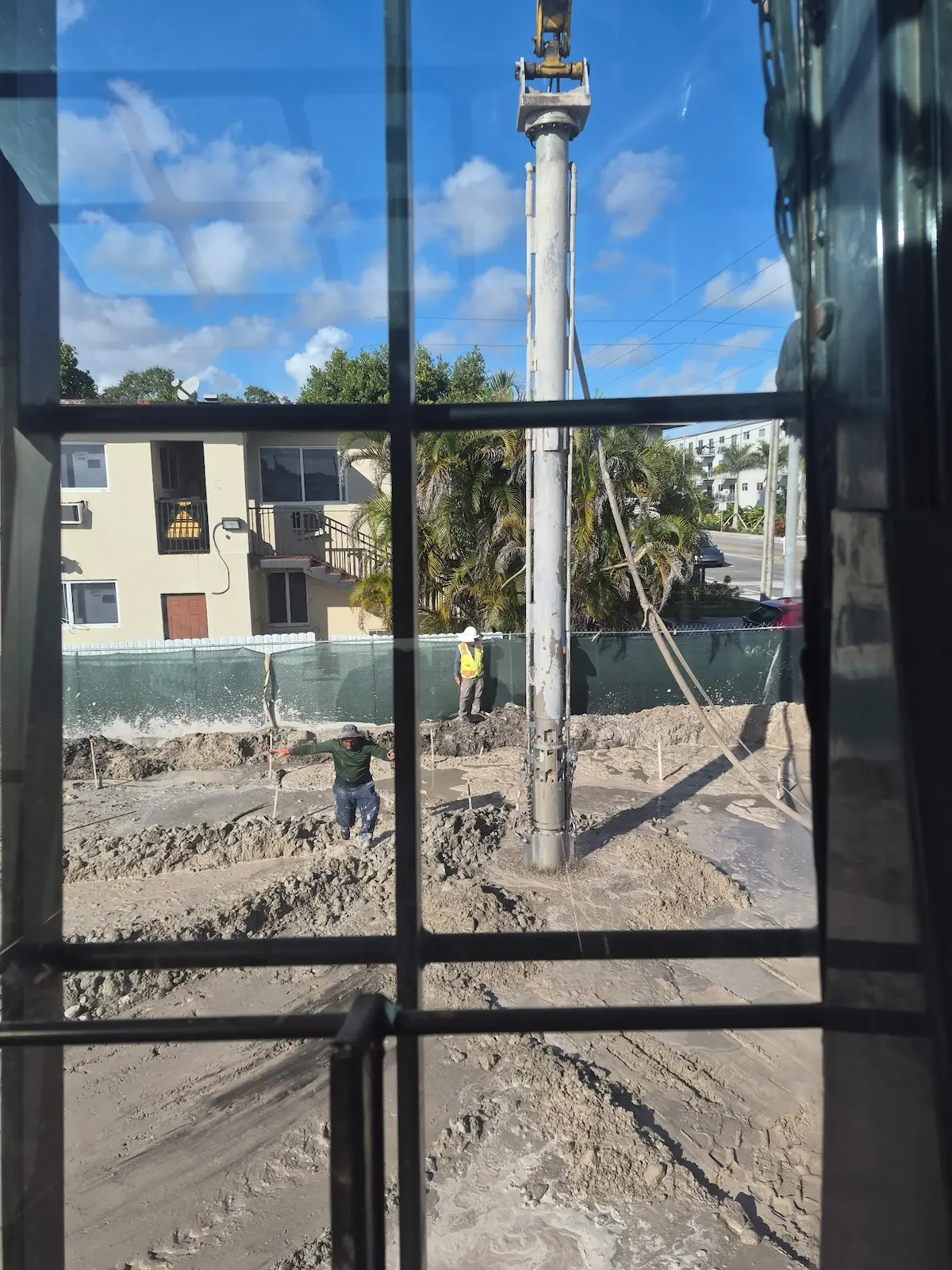 Crew installing piles next to a building